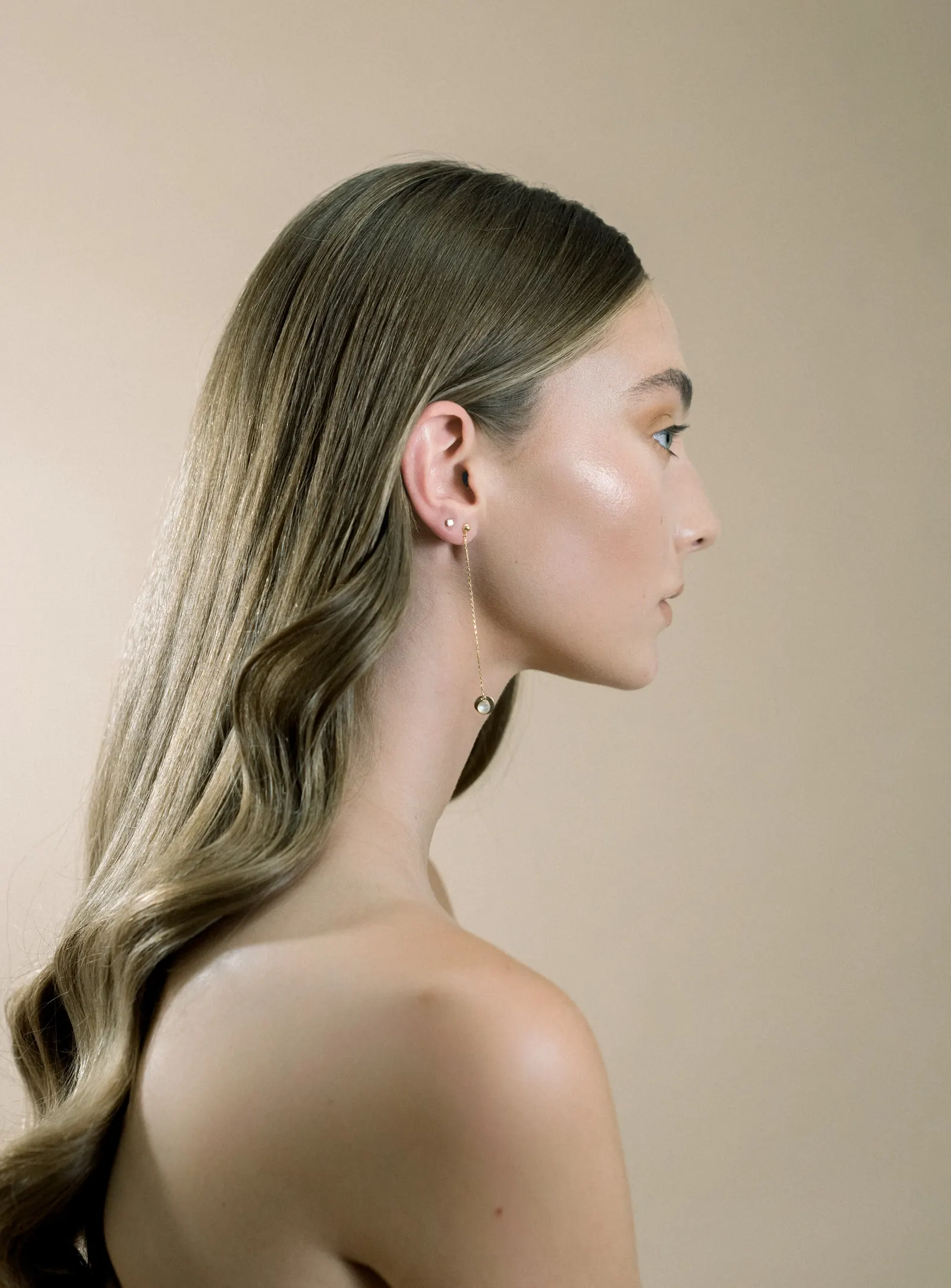 Profile of a woman with long sleek blonde hair and luminous skin